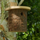 Natural Log Bird Nester (Green) - The Irish Gardener Store Natural Log Bird Nester, rustic wooden design with natural bark exterior, green-painted slanted roof, circular entrance hole for small birds, eco-friendly bird nesting box, ideal for garden and outdoor use, wildlife-friendly habitat