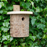 Natural Log Bird Nester (Green) - The Irish Gardener Store Natural Log Bird Nester, rustic wooden design with natural bark exterior, green-painted slanted roof, circular entrance hole for small birds, eco-friendly bird nesting box, ideal for garden and outdoor use, wildlife-friendly habitat