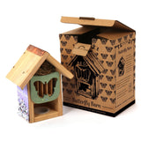 "Butterfly Barn, wooden construction with butterfly-shaped entrance, eco-friendly design, copper roof detail, natural nesting materials inside, packaged in a decorative cardboard box, ideal for supporting pollinators, sustainable garden accessory"