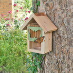 Butterfly Barn, wooden structure with butterfly-shaped entrance, attached to a tree trunk, copper roof detail, surrounded by natural greenery and flowers, butterfly resting on the entrance, eco-friendly pollinator shelter, ideal for gardens