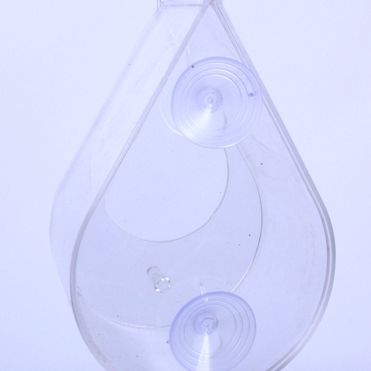 Transparent dewdrop-shaped window bird feeder, made of clear acrylic, featuring two suction cups for secure window attachment, lightweight and modern design, rope accent for optional hanging, empty open tray design, minimalistic bird feeder style