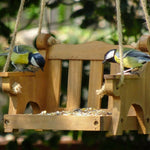 Swingseat Bird Feeder - The Irish Gardener Store natural wooden swingseat bird feeder, hanging bird feeder on ropes, rustic garden decor, wooden swing bird feeder for seeds, outdoor bird feeding station, eco-friendly bird feeder hanging in garden, bird feeder in countryside setting, handcrafted wooden swing bird feeder
