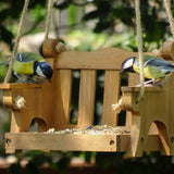 Swingseat Bird Feeder - The Irish Gardener Store natural wooden swingseat bird feeder, hanging bird feeder on ropes, rustic garden decor, wooden swing bird feeder for seeds, outdoor bird feeding station, eco-friendly bird feeder hanging in garden, bird feeder in countryside setting, handcrafted wooden swing bird feeder