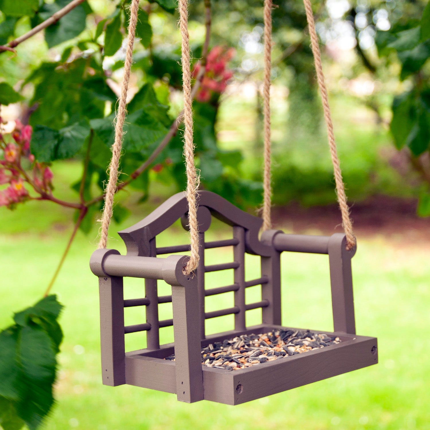 Timeless Lutyens Swingseat Bird Feeder - The Irish Gardener Store Timeless Lutyens Swingseat Bird Feeder hanging in a garden, wooden swing design for feeding birds, durable rope suspension, classic Lutyens-inspired style, weather-resistant bird feeder, decorative garden bird feeder, close-up of wooden swing bird feeder, perfect for small birds like sparrows and finches, garden wildlife attraction, stylish bird feeder for outdoor spaces