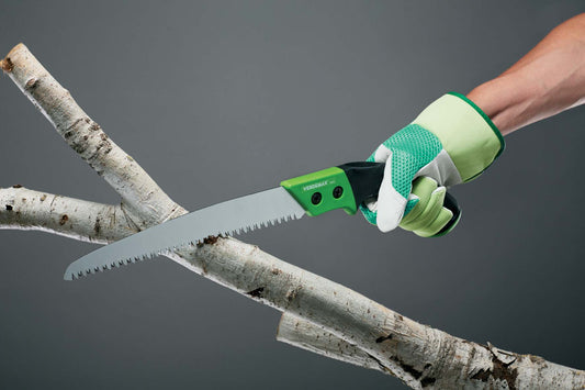 A person using the Verdemax Fixed Blade Handsaw to cut through a branch. The saw features a green and black ergonomic handle, and a sharp blade with deep cutting teeth. The image showcases the handsaw in action, demonstrating its precision and efficiency in pruning tasks.