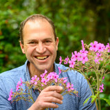 Peter Dowdall smiling in a garden setting with summer planting