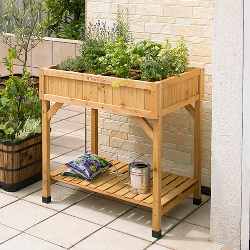 Image of the VegTrug Herb Garden showcasing its raised wooden design with eight pockets for growing fresh herbs in a balcony or patio setting.