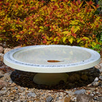 Shenstone Theatre Bird Bath and Drinker - The Irish Gardener Store shenstone Theatre Bird Bath and Drinker on a stone pedestal, , elegant circular design, smooth cream-colored surface, engraved rim detailing, outdoor garden setting, bird-friendly garden feature.