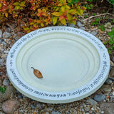 Shenstone Theatre Bird Bath and Drinker - The Irish Gardener Store shenstone Theatre Bird Bath and Drinker on a stone pedestal, , elegant circular design, smooth cream-colored surface, engraved rim detailing, outdoor garden setting, bird-friendly garden feature.