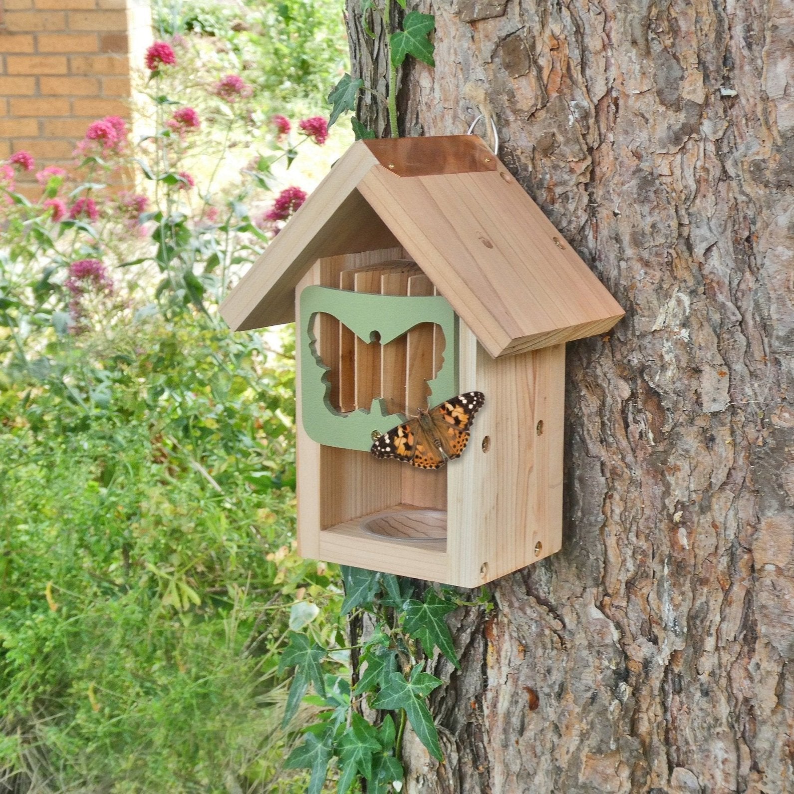 Butterfly Barn, wooden structure with butterfly-shaped entrance, attached to a tree trunk, copper roof detail, surrounded by natural greenery and flowers, butterfly resting on the entrance, eco-friendly pollinator shelter, ideal for gardens