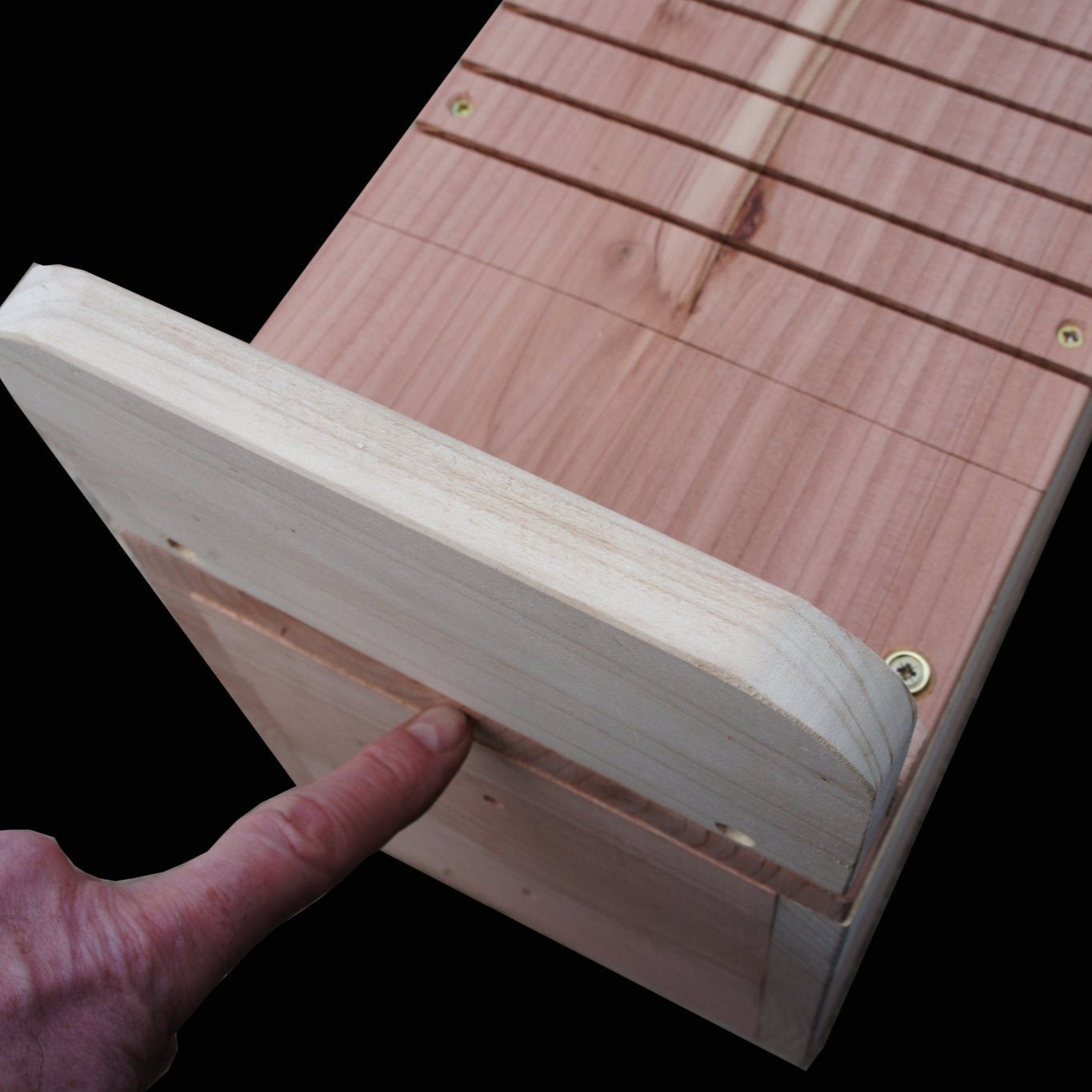 Red Squirrel Nest Box - The Irish Gardener Store Red Squirrel Nest Box, wooden construction with natural finish,circular entrance hole, horizontal grooves for climbing, weather-resistant design, spacious interior, eco-friendly wildlife shelter, ideal for red squirrels, located in a natural outdoor setting, sustainable conservation habitat
