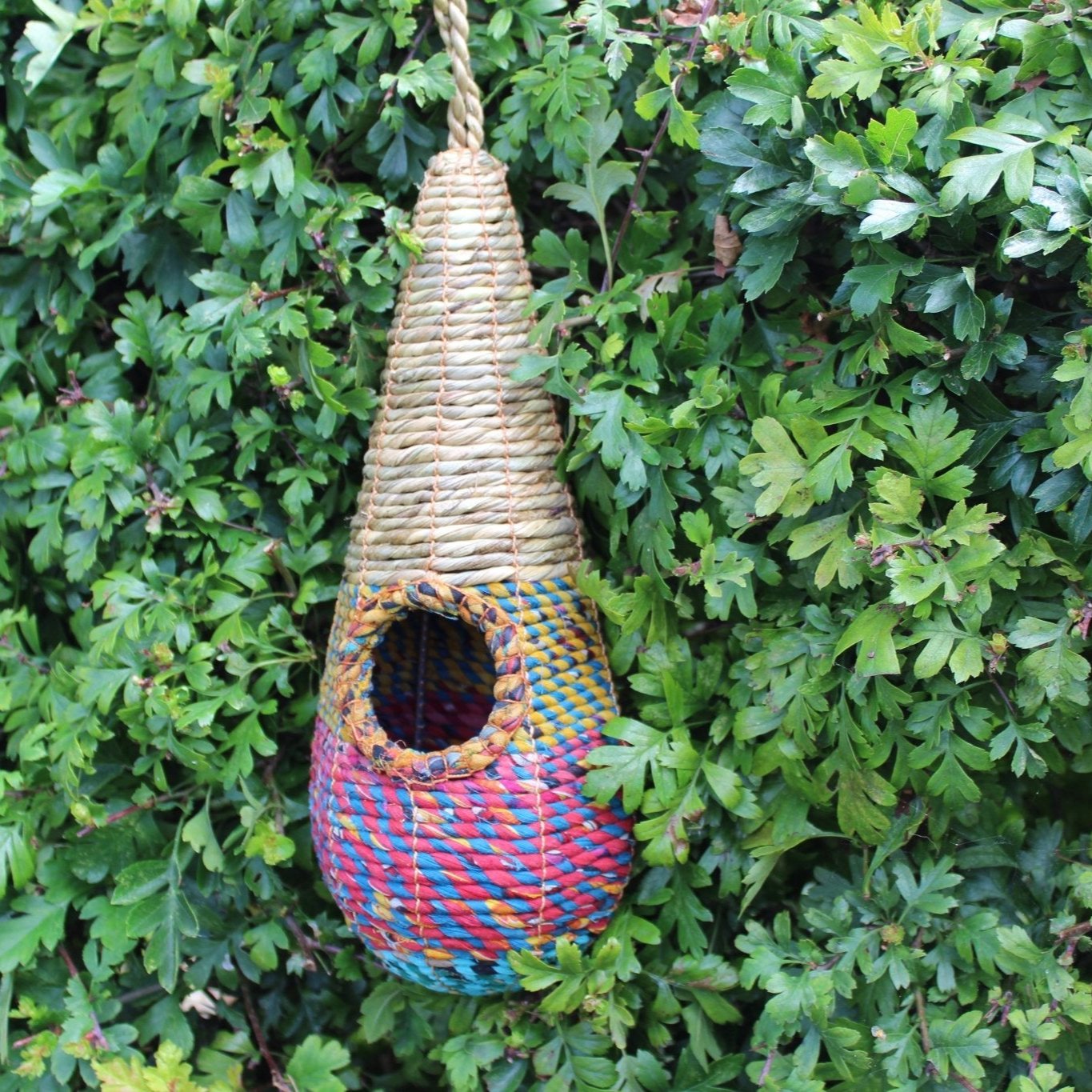 Tahera - Artisan Bird Nester - The Irish Gardener Store handcrafted Tahera Artisan Bird Nester, eco-friendly woven bird house, vibrant natural fiber bird nester, sustainable bird shelter with colorful design, cone-shaped hanging bird nester, rustic garden birdhouse, artisan-crafted nesting habitat