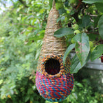 Tahera - Artisan Bird Nester - The Irish Gardener Storehandcrafted Tahera Artisan Bird Nester, eco-friendly woven bird house, vibrant natural fiber bird nester, sustainable bird shelter with colorful design, cone-shaped hanging bird nester, rustic garden birdhouse, artisan-crafted nesting habitat